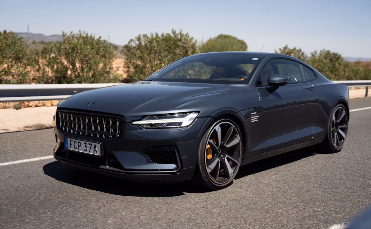 A Polestar 1 in the colour Black Midnight driving on a road.