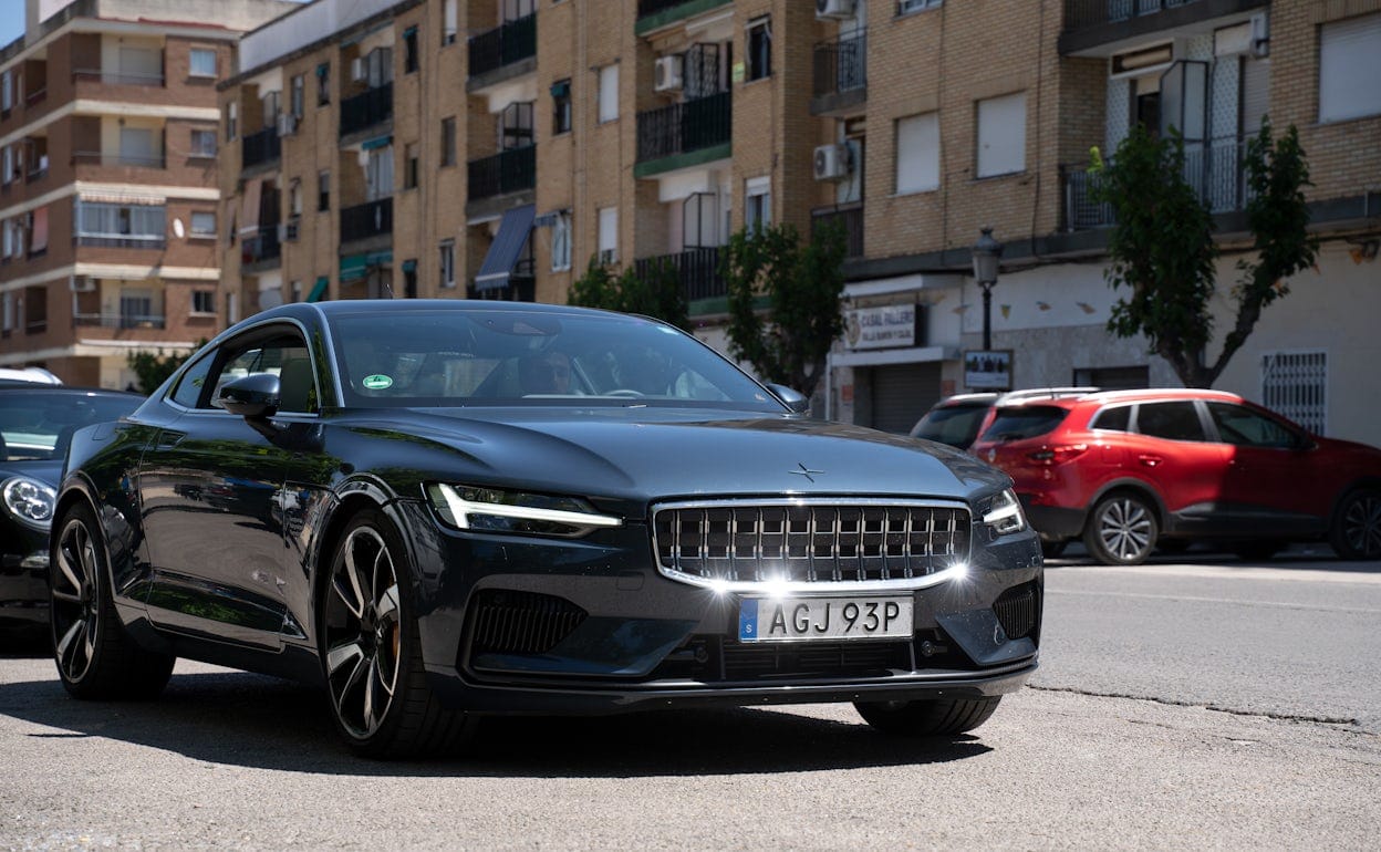 Front view of a pristine Polestar 1 in the colour Black Midnight driving on the road.