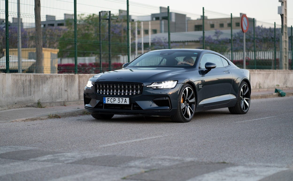 Front view of a Polestar 1 in the colour Black Midnight driving on a road.