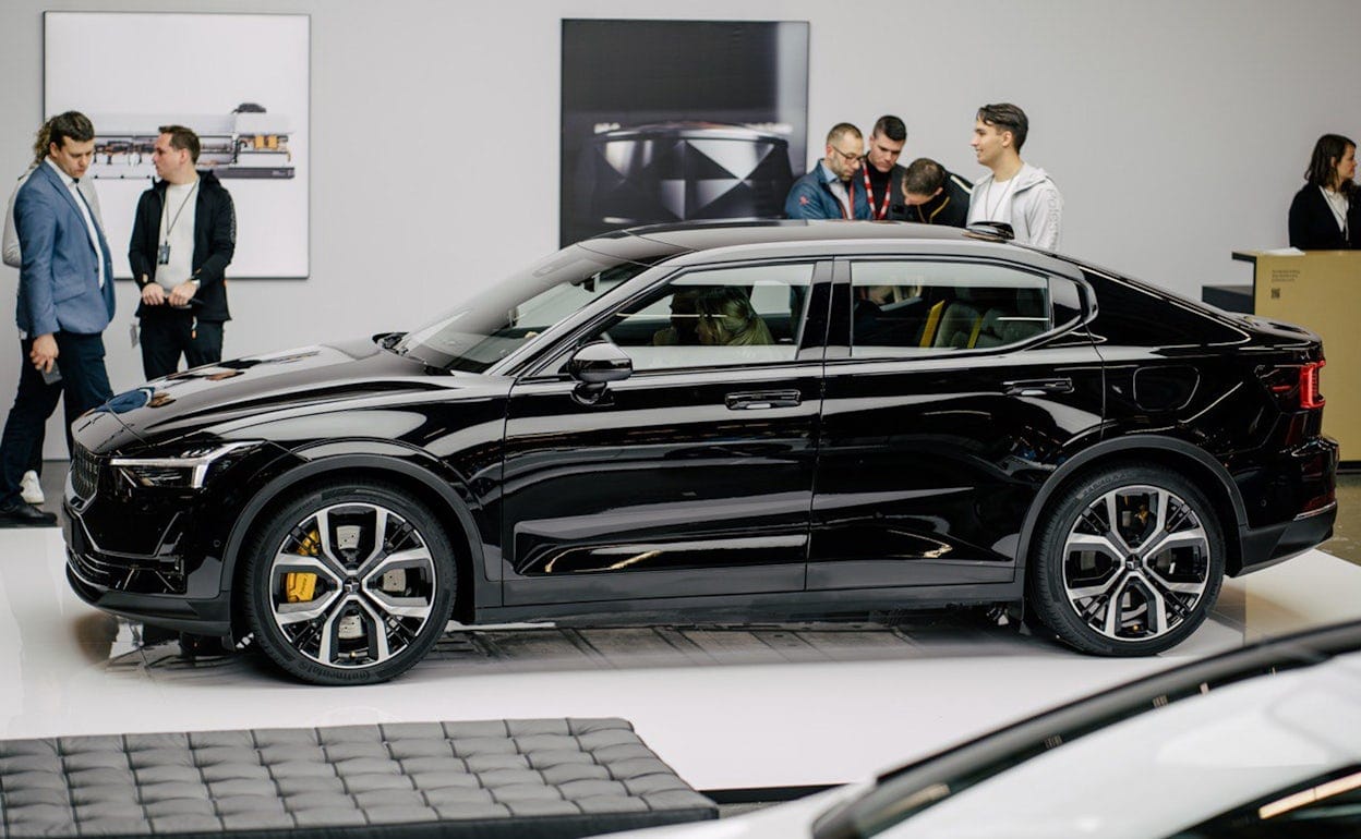 Side view of a black Polestar 2 with visitors gathered around it at Ecar expo 2019.