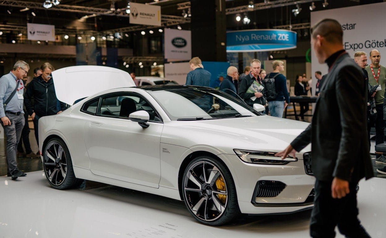 Event visitors inspecting a white Polestar 1 at Ecar expo 2019.