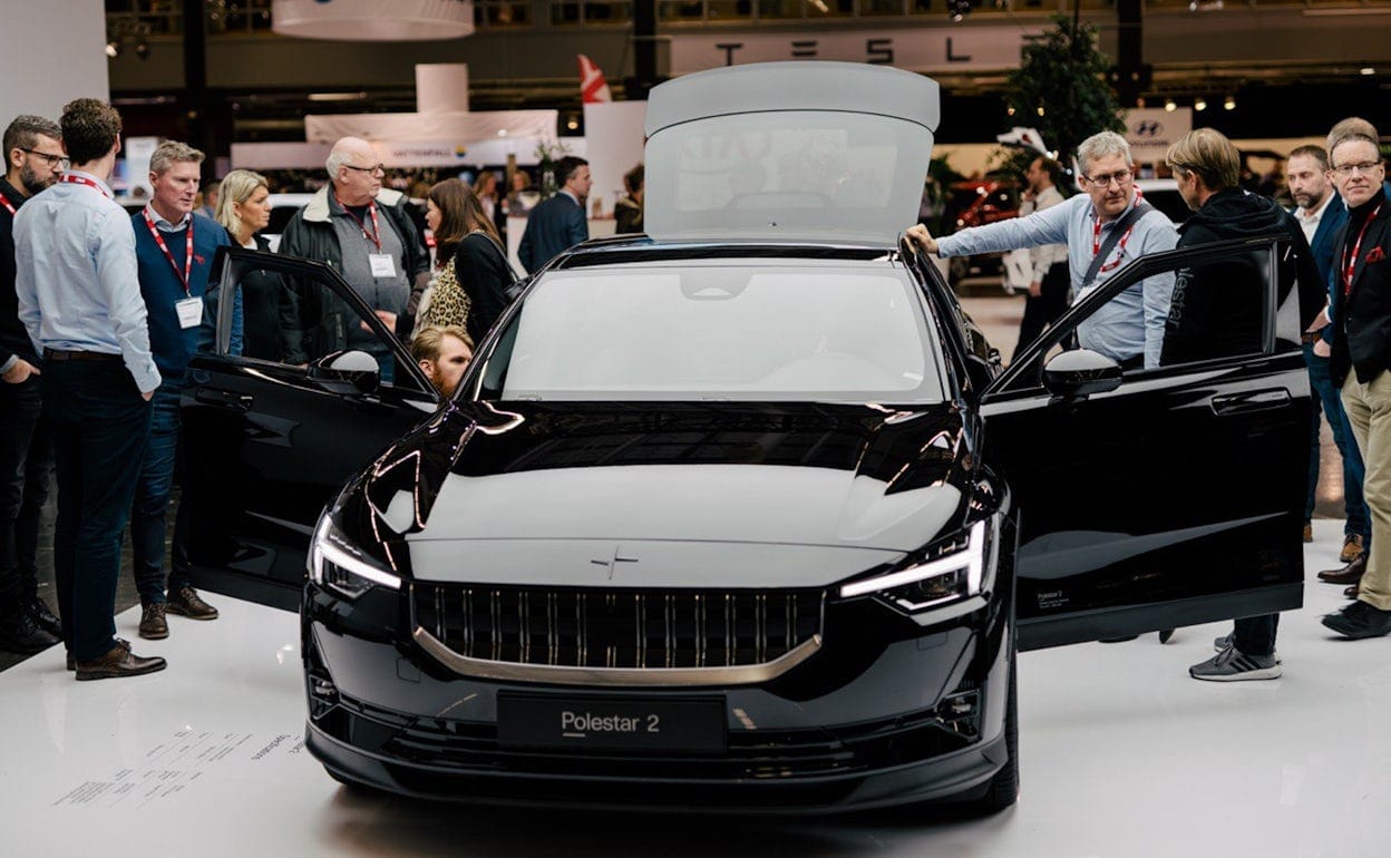 People looking at a black Polestar 2 with open doors at Ecar expo 2019