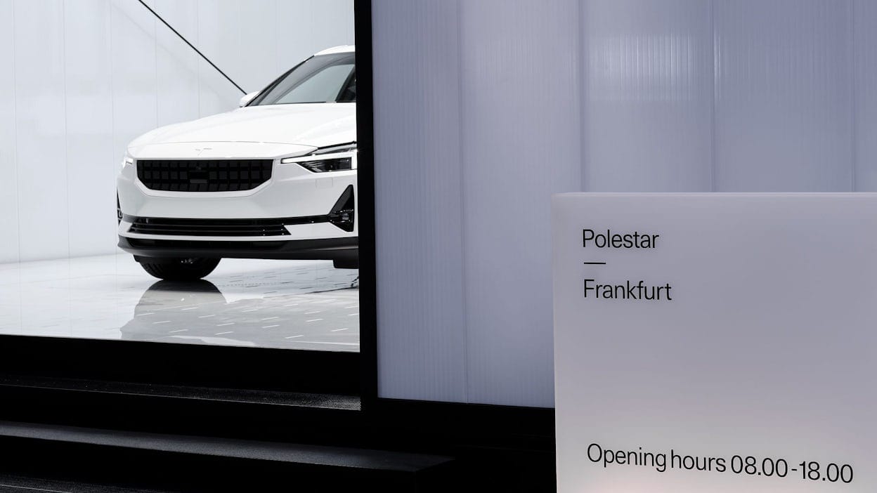 A white Polestar 2 on display behind a sign that reads Polestar Frankfurt.