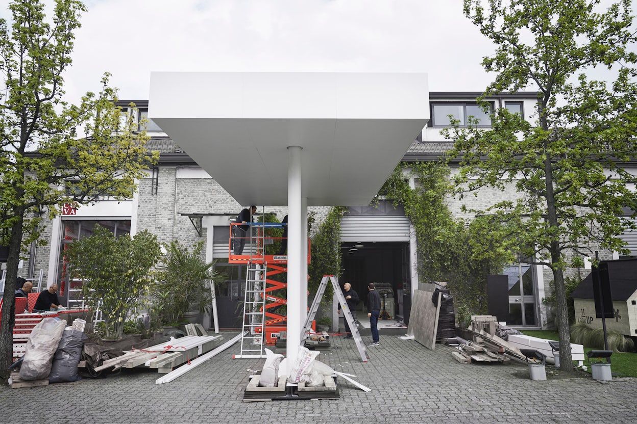 A white Polestar charging station under construction outside a house.