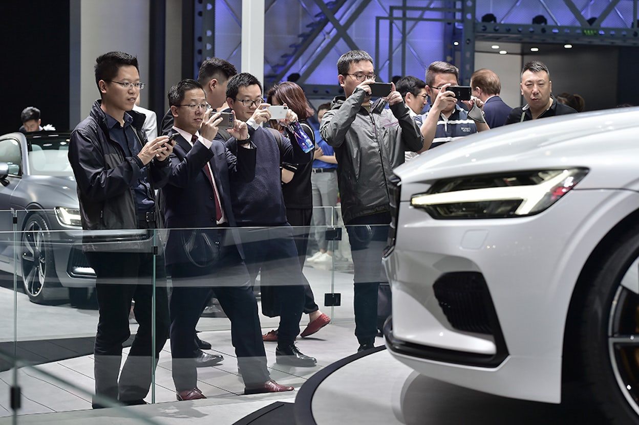 The front of a white Polestar 1 with people photographing it in focus