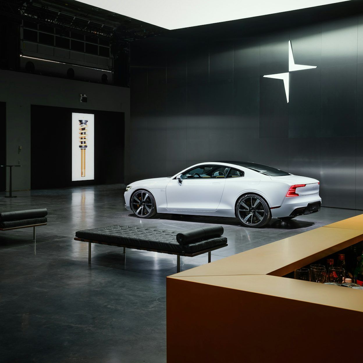 A Polestar parked in front of a black wall with the Polestar logo