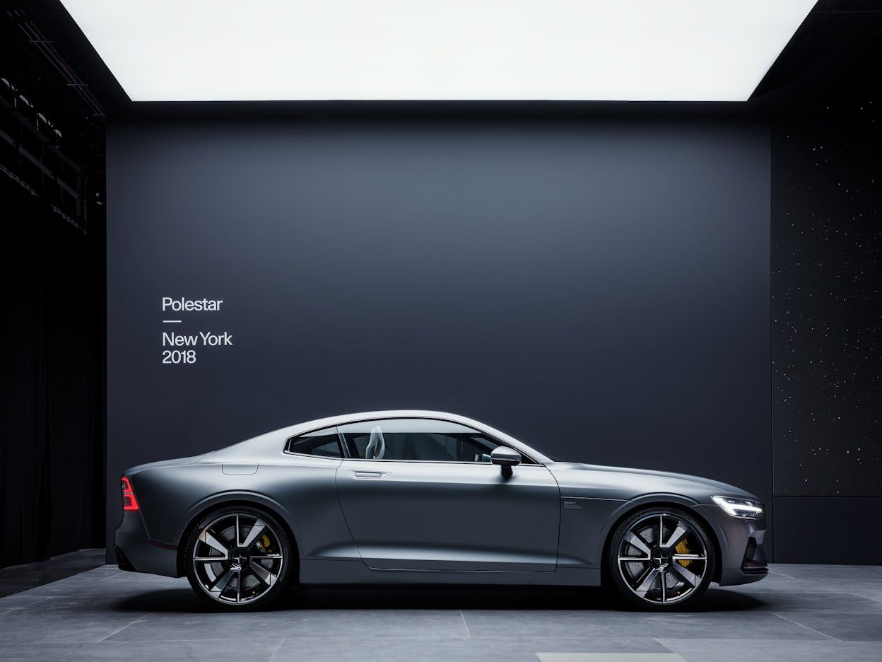 A silver Polestar 1 on display in front of a black wall with the text Polestar New York 2018