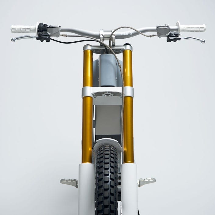 A white and gold bicycle viewed from the front
