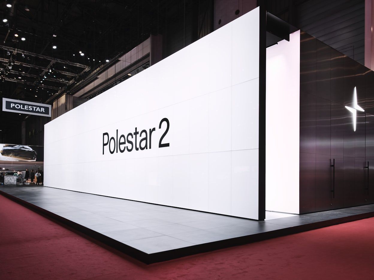 A black and white Polestar 2 stand with the Polestar logo viewed from the side