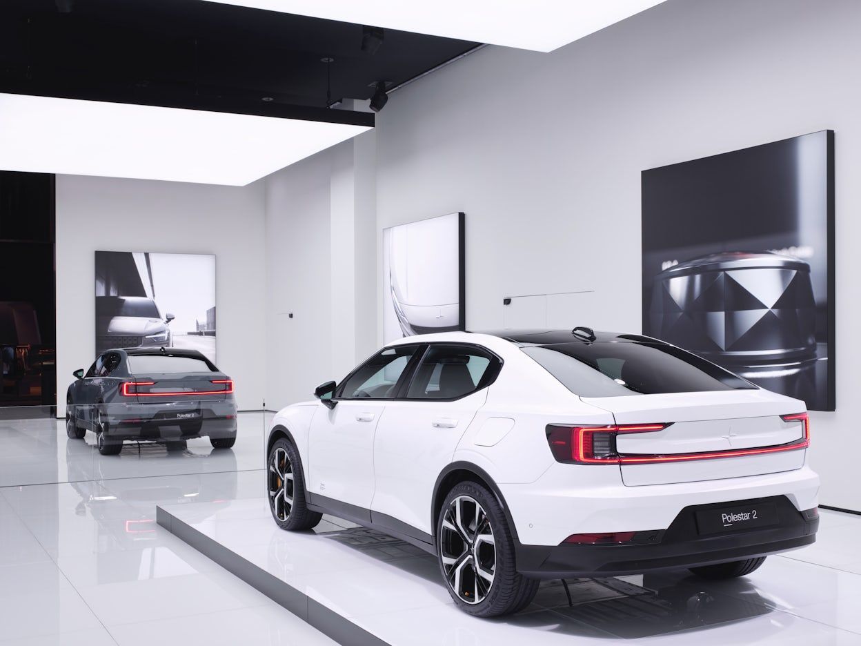 Back view of two Polestar 2 cars in a white, minimalistic Polestar space.