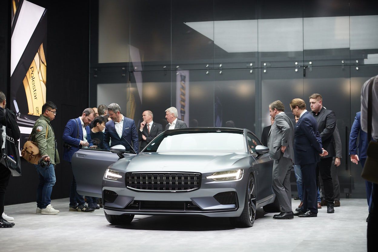 People gathered around a silver Polestar 1 on display.