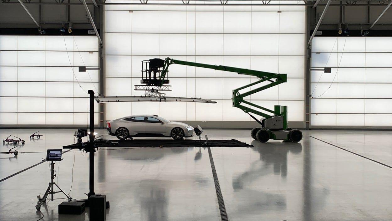 A crane above a Polestar Precept in a large warehouse.
