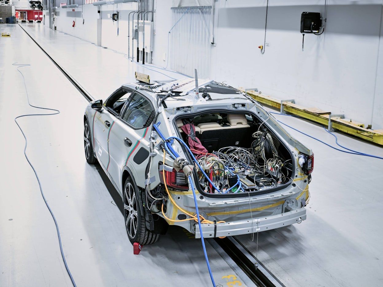 The crash test tunnel with a Polestar 2 connected to cables.
