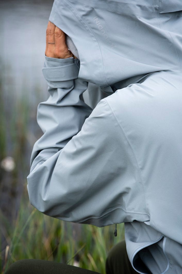 Close-up of a person in a grey raincoat.