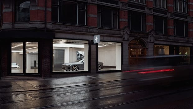 A street corner with a Polestar space where a Polestar 1 is visible through large glass windows.