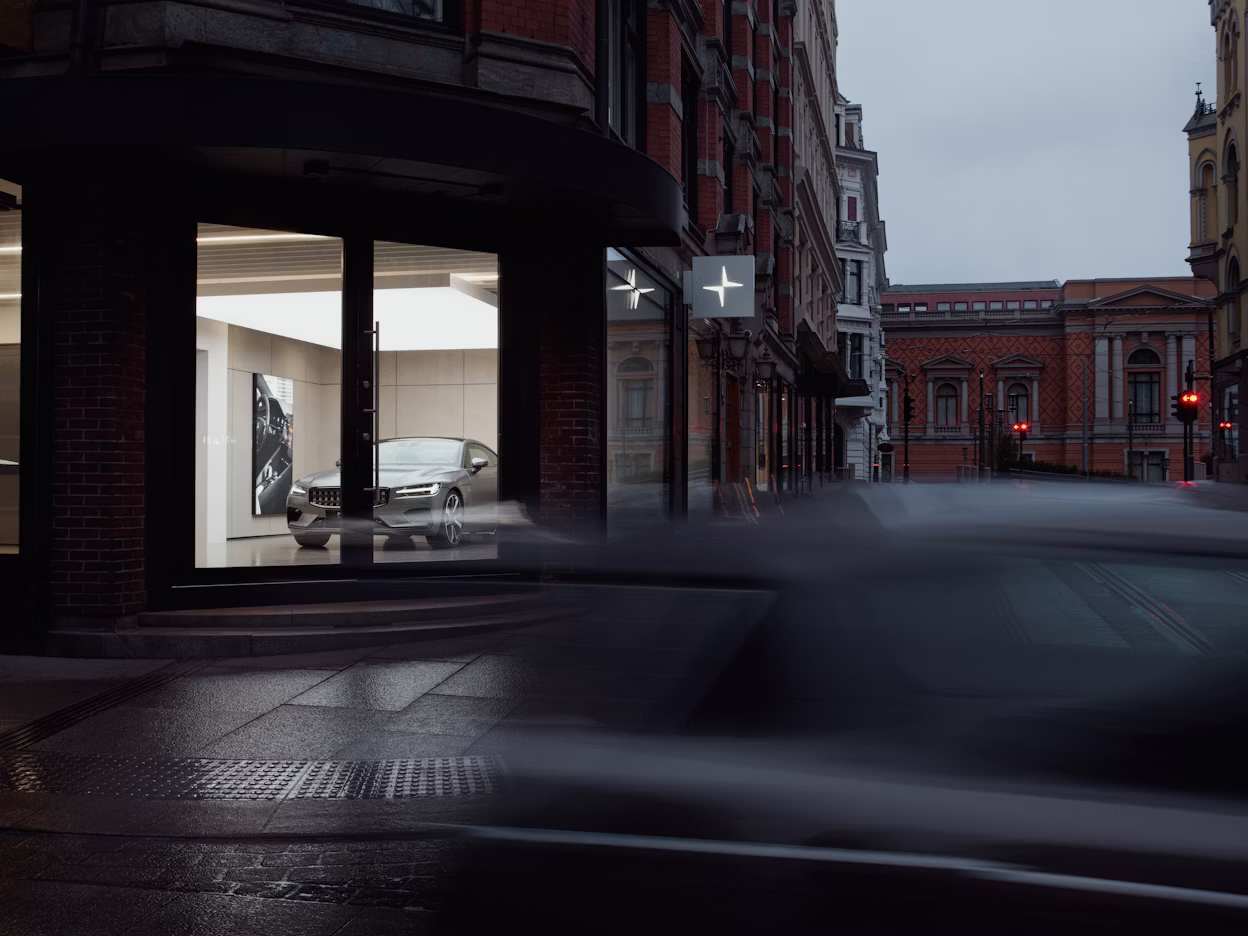 A street corner with a Polestar space visible through glass doors.
