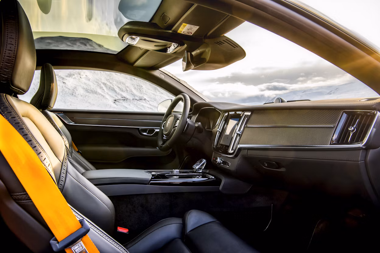 The interior of a Polestar 1 with black seats and yellow seatbelts.