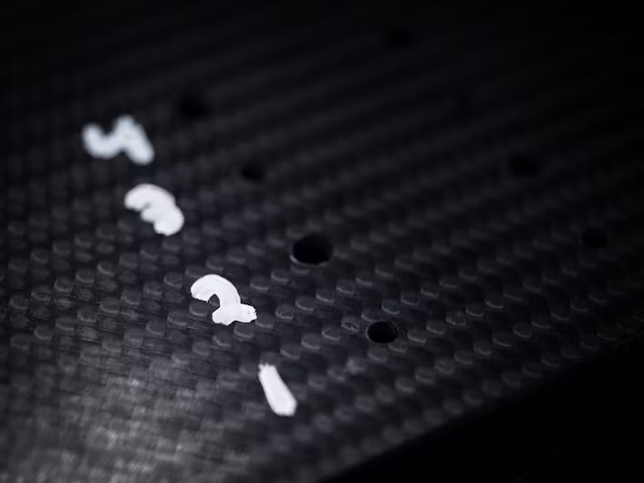 The numbers one to four written on black carbon fibre