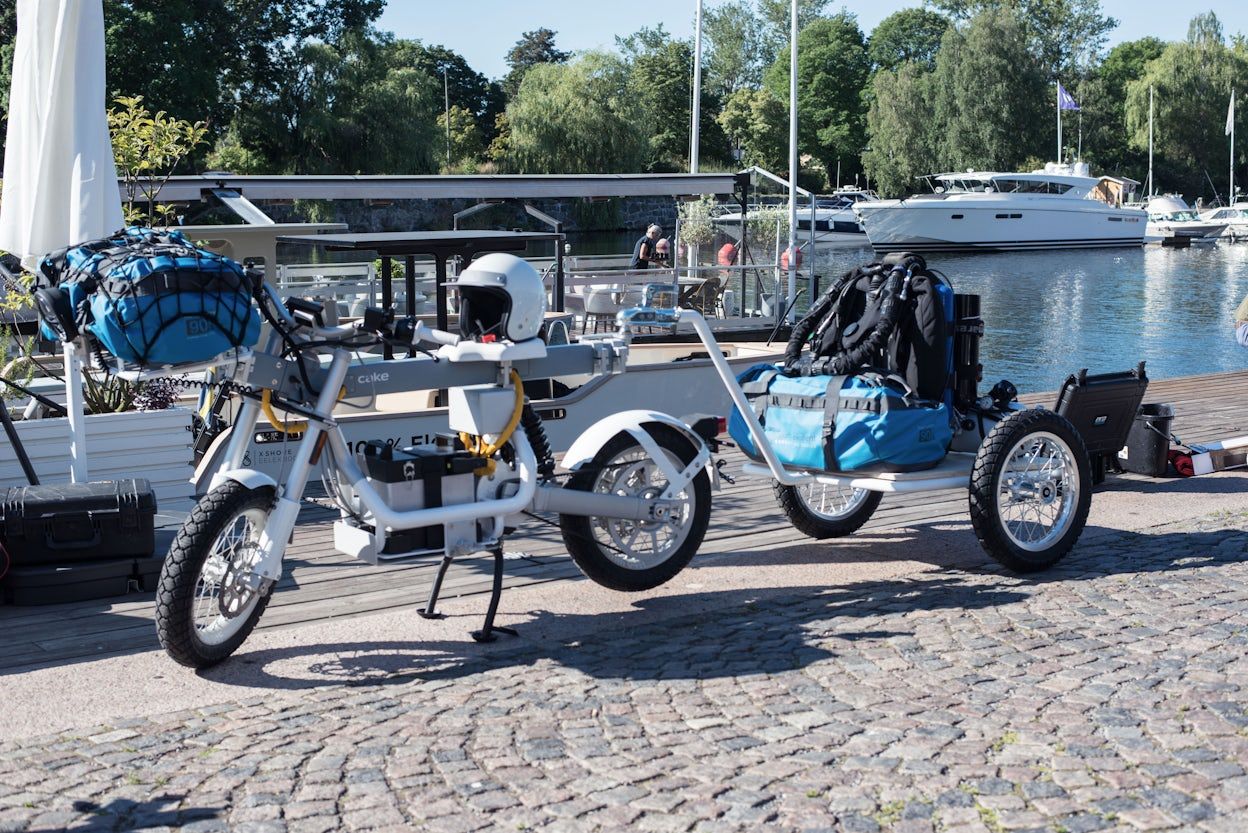 An electric motorbike parked in front of a boat on a sunny day