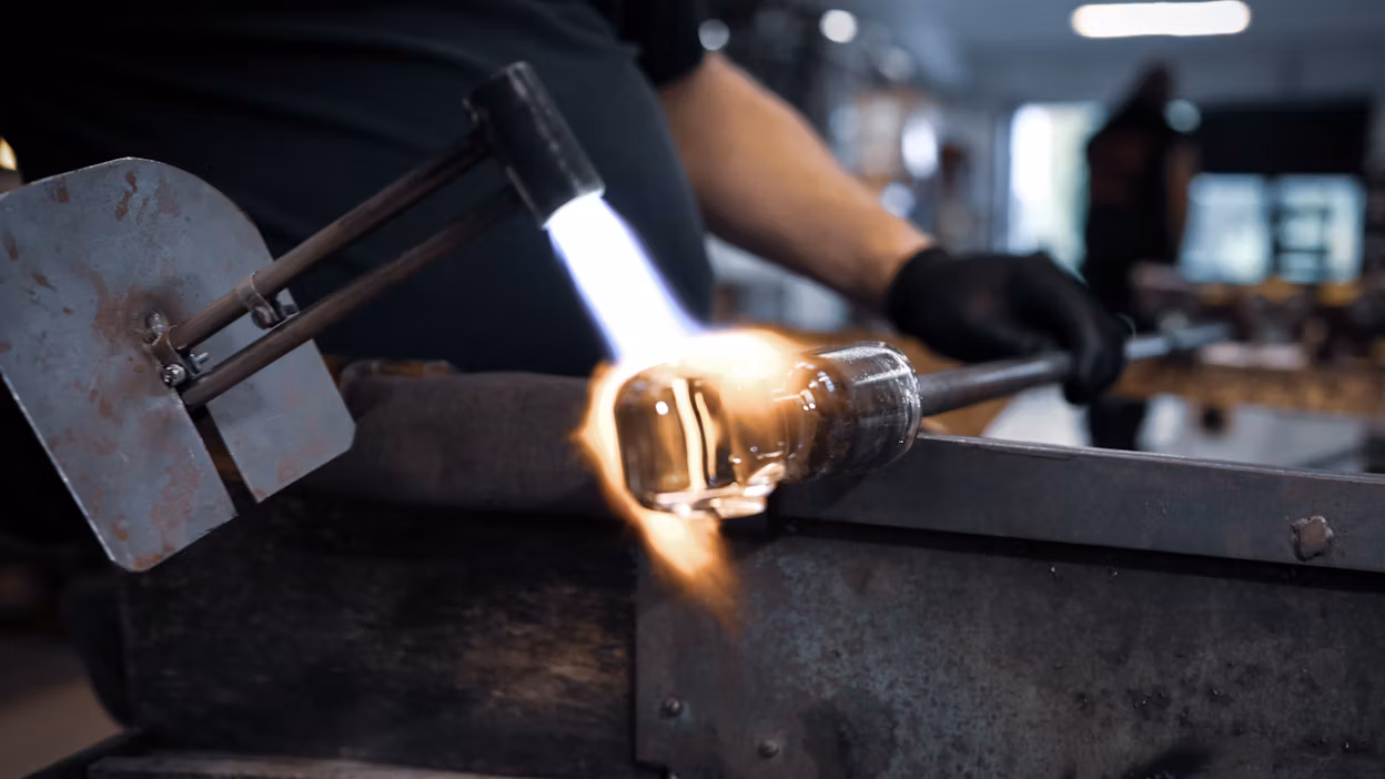 Close-up of a glass artisan making a gearshift out of lead-free crystal.