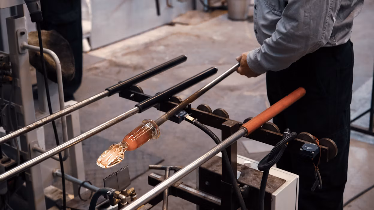 Glass being shaped by a glass artisan.