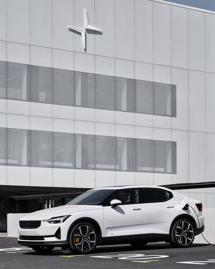 White Polestar 2 parked outside a white modern building while charging 
