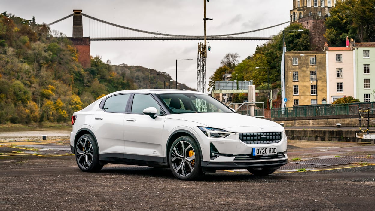 A white Polestar 2 parked in front of bridge