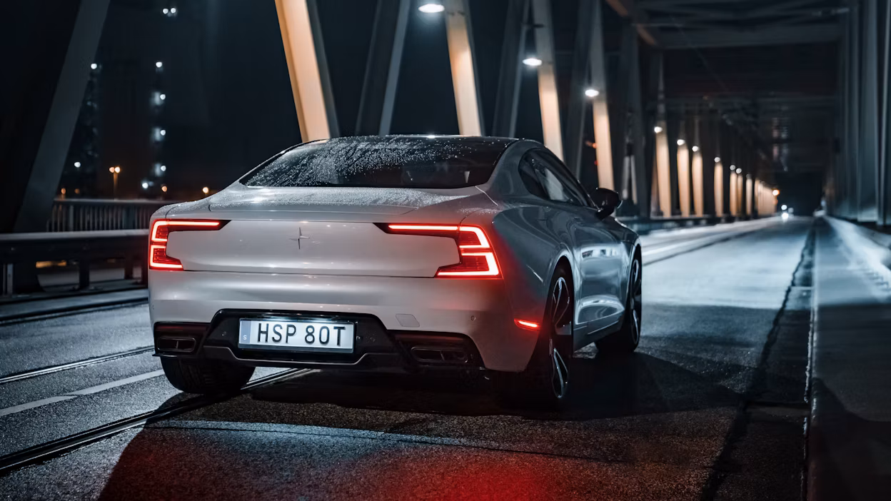 Back view of a Polestar 1 driving on a bridge at night.