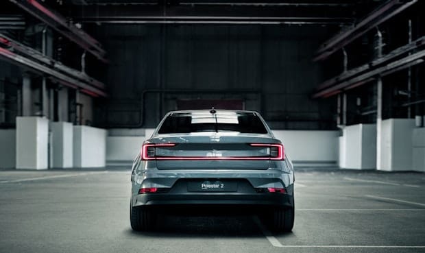 Back view of a grey Polestar 2 parked in a concrete garage.