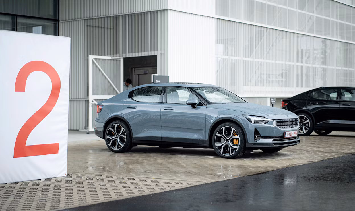 Polestar cars parked near a building with a large sign displaying the number 2.