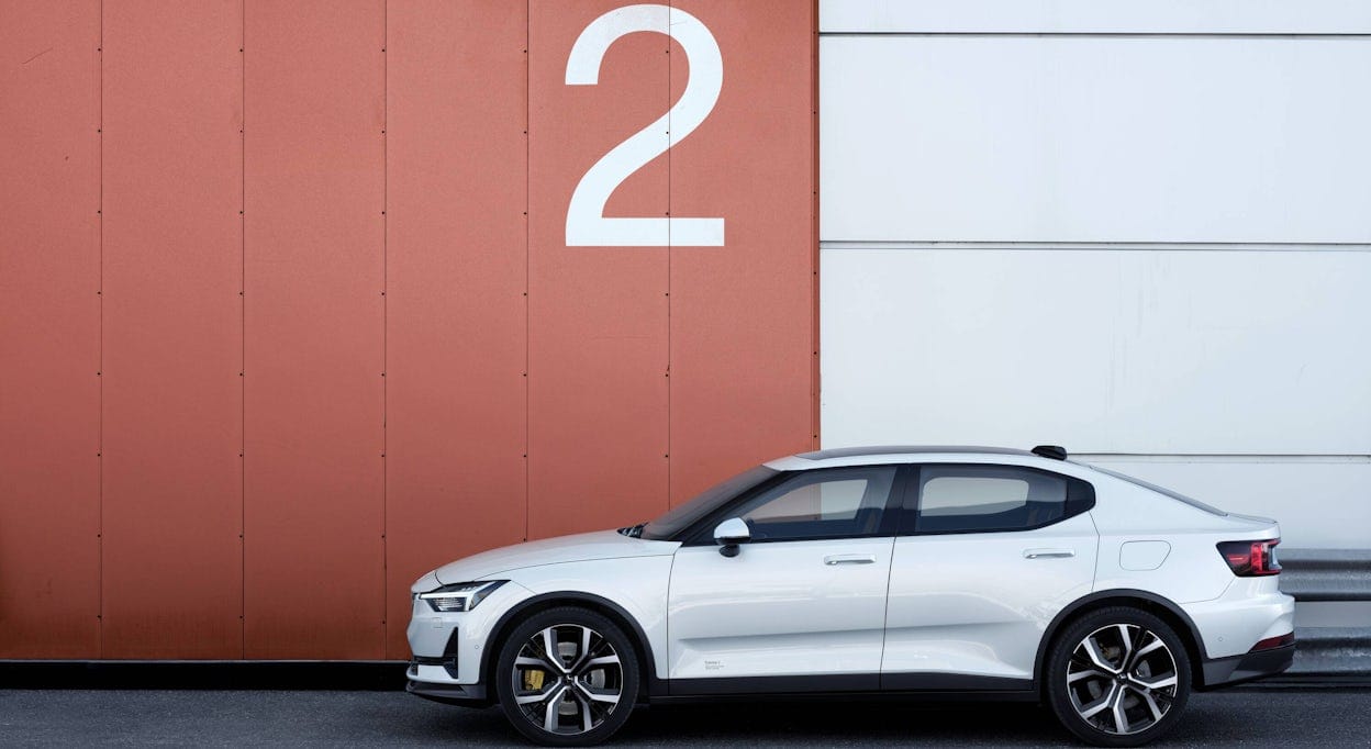 Polestar 2 in white in front of a wall with a large number two on it