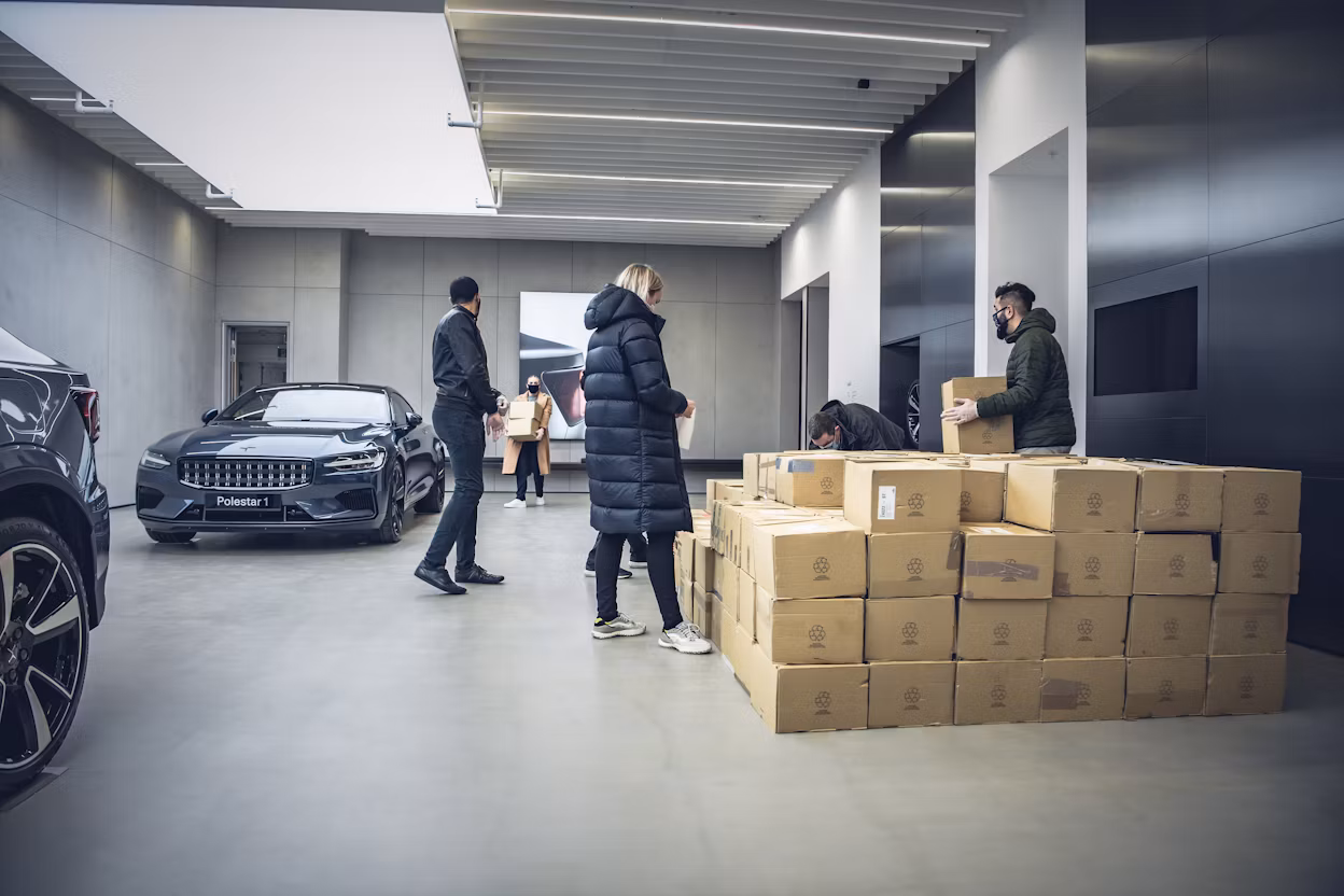 Polestar staff preparing donations in cardboard boxes inside a Polestar space.