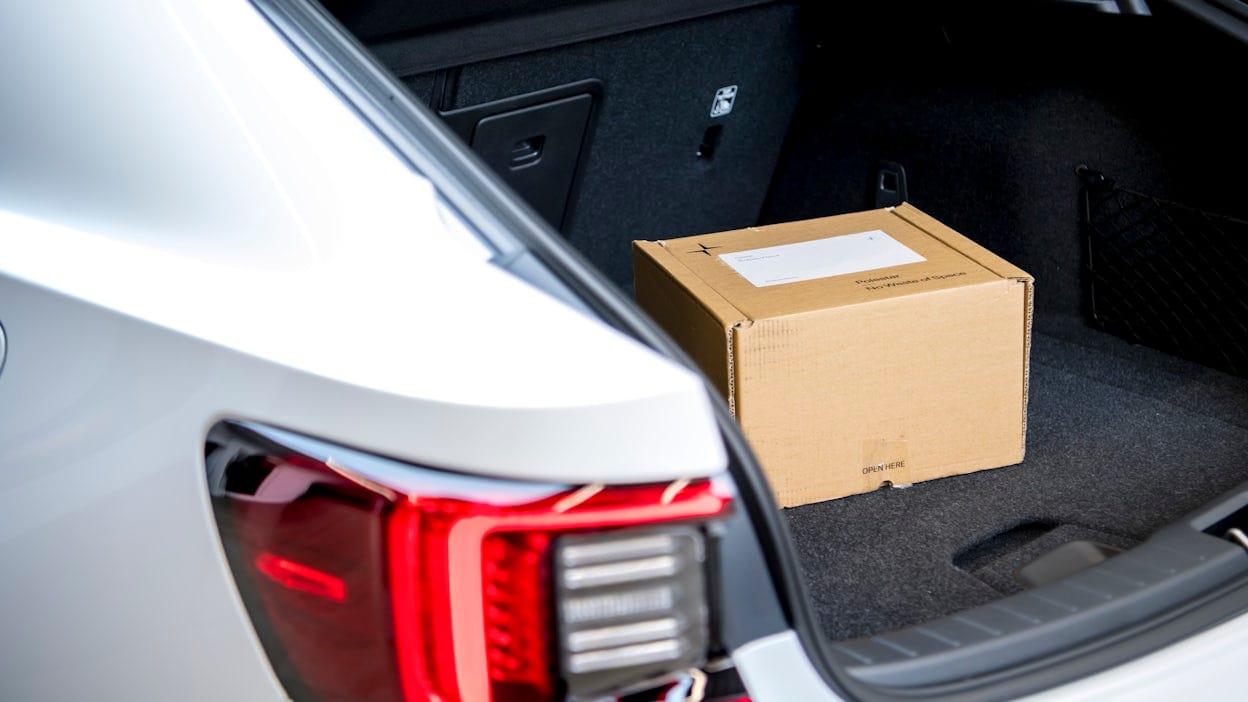 Cardboard box placed inside the trunk of a white Polestar 2.