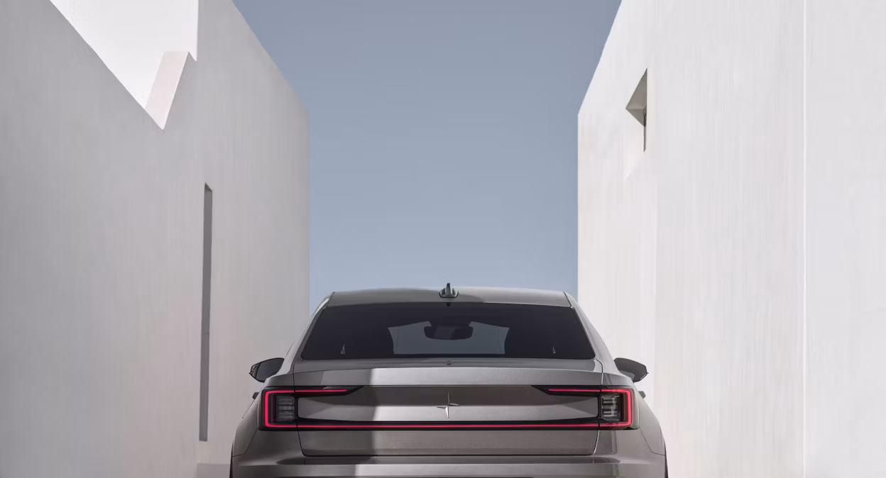 Beige Polestar 2 parked between two white stone buildings