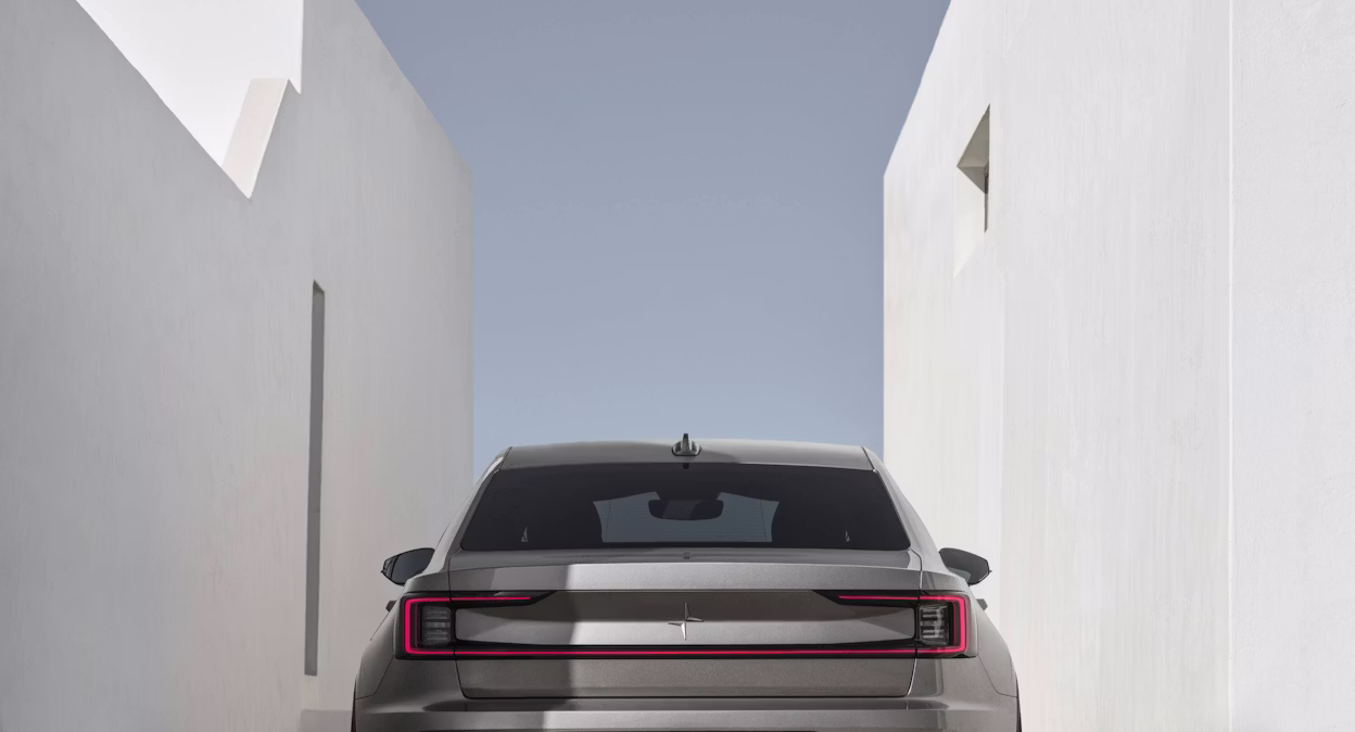 Beige Polestar 2 parked between two white stone buildings
