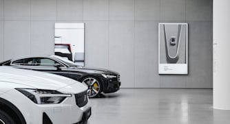 Polestar cars displayed in a grey Polestar space with detail images hanging on the wall.