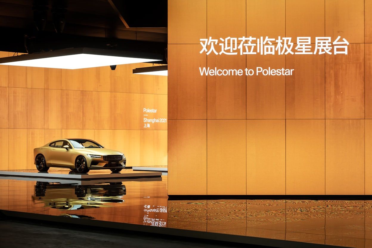 Golden Polestar 1 displayed on a orange-lit stage at the Auto Shanghai show 2021.