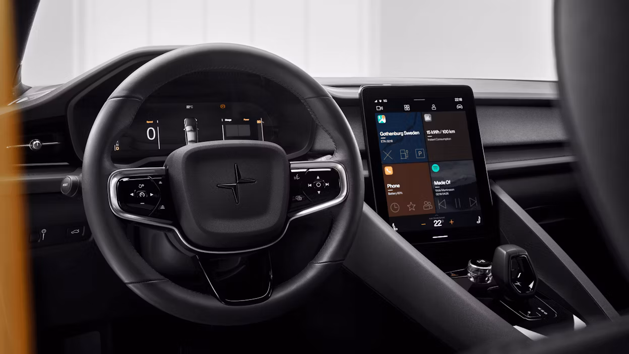 Interior by the driver seat of a Polestar 2 showing the steering wheel and in-car display.