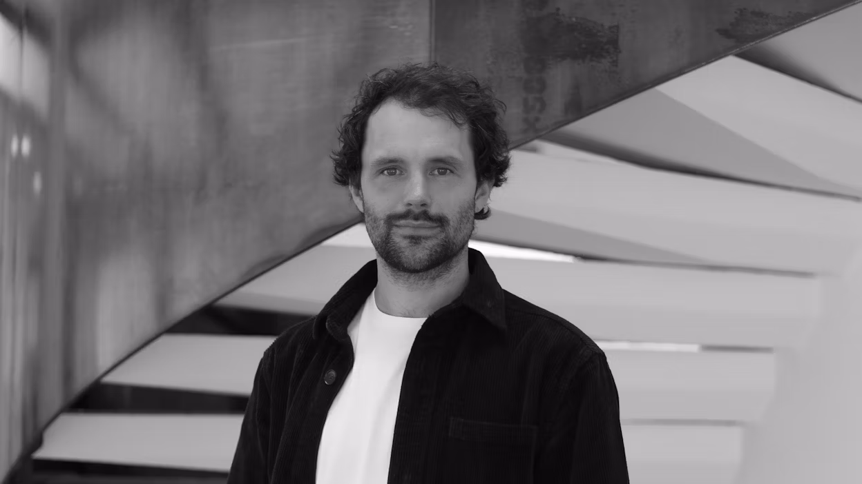 Fredrik Backson looking into the camera, standing in front of a set of stairs.