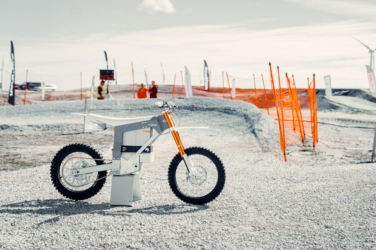 Cake mountain bike displayed on gravel with orange safety net in the background