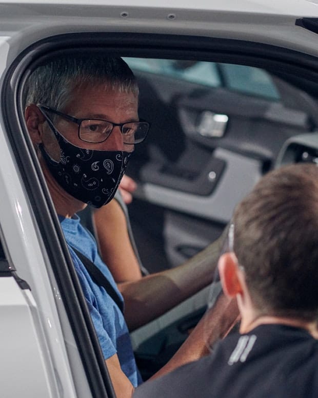 Man is sitting inside Polestar 2 wearing a mask during Polestar 2 test drive to protect himself from Covid-19 
