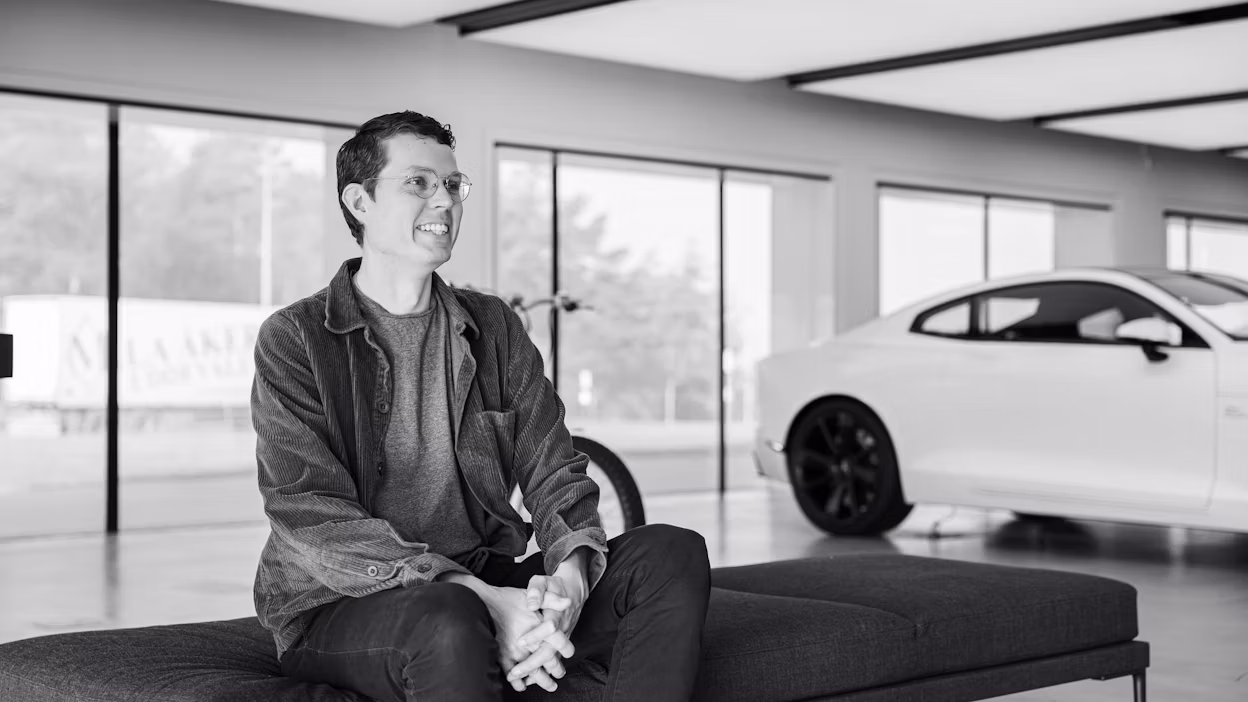 Sander Jahilo sitting on a bench in a Polestar space.