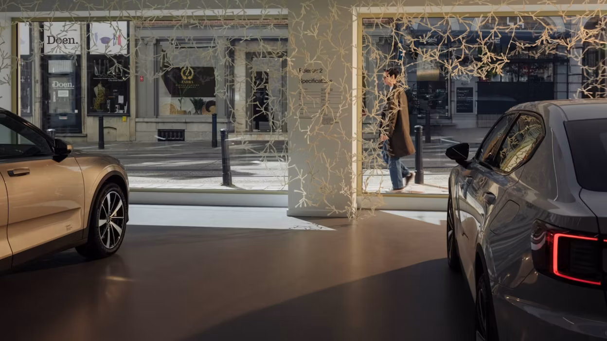 A modular room divider made from bioplastics hanging in a Polestar in front of two cars.