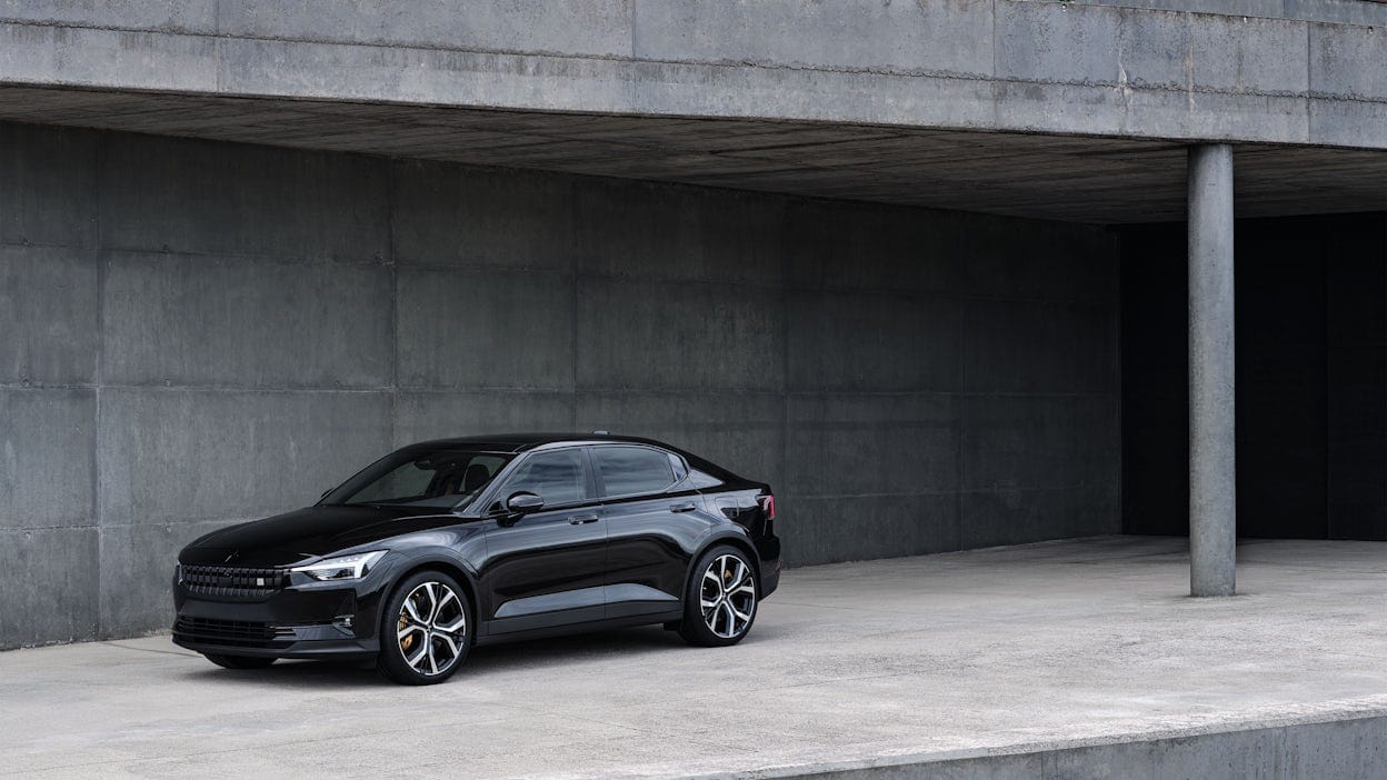 A Polestar 2 in front of a cement wall.
