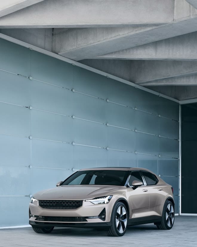 A Polestar 2 in front of a glass wall.