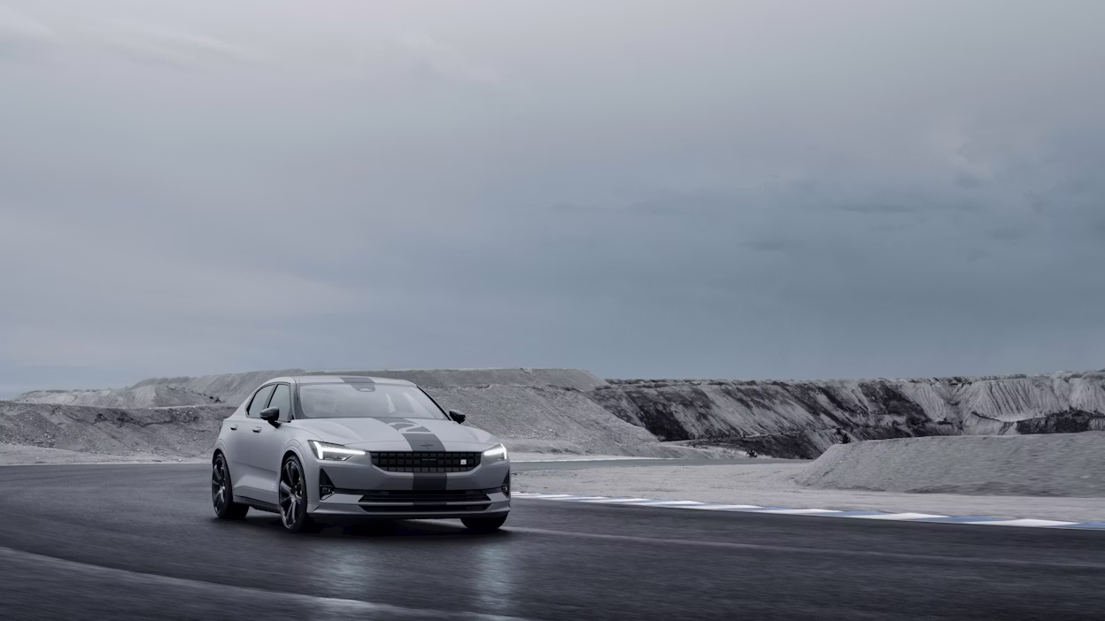 A Polestar 2 driving on a track near a quarry.