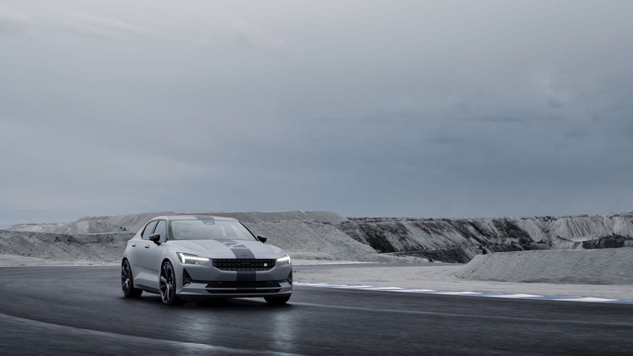 A Polestar 2 with a racing stripe driving on a track. 