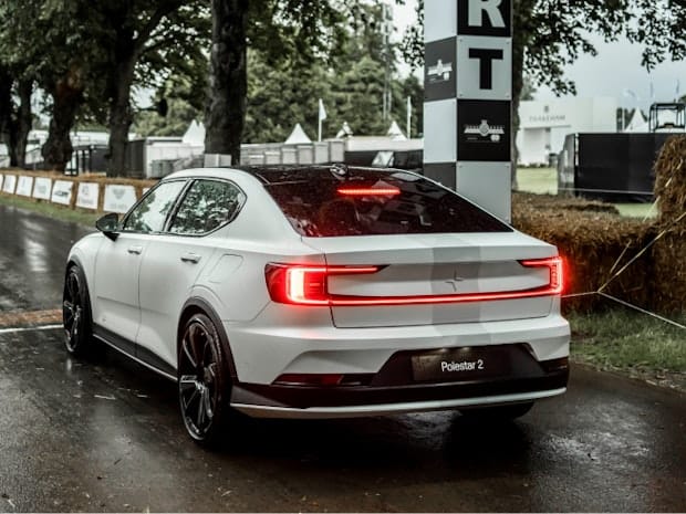 Rear and side view of Polestar 2 BST edition 270, race stripe adorned in pole position on a racing track