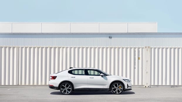 A white polestar 2 parked in front of a white container 
