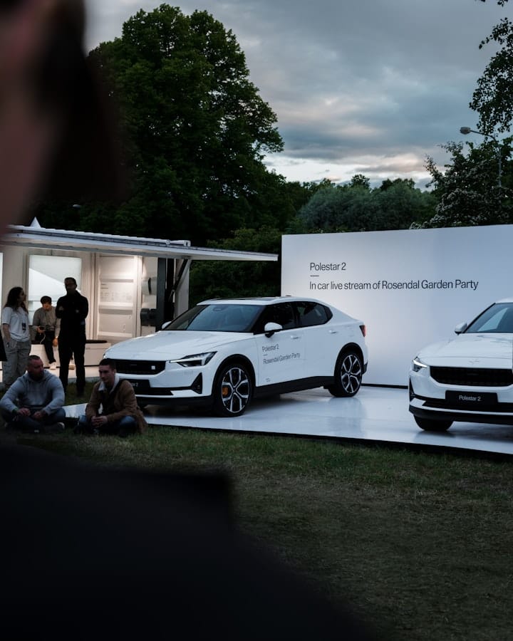 White Polestar 2s on a white stage in the evening.